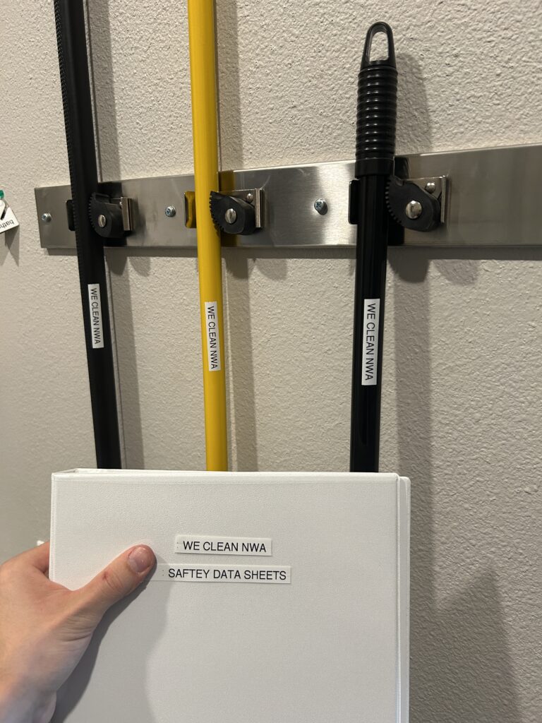 Professional janitorial equipment and SDS safety books used by WE Clean NWA commercial cleaning technicians.